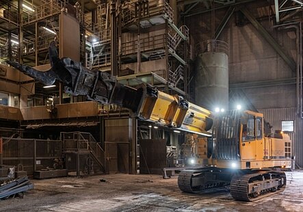 Unidachs 740, telescopic excavator with crawler undercarriage working in a steel plant, with ripper hook attachment