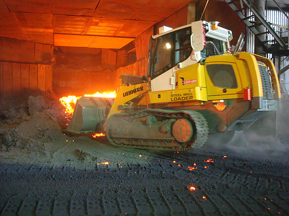 TML Steel Mill Loader cleaning under a furnace
