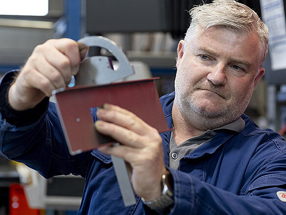 Un trabajador examinando un componente de metal